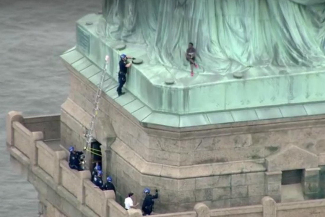 Protesta por política migratoria: mujer intenta escalar la Estatua de la Libertad