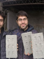 Tres jóvenes fabrican ladrillos con botellas plásticas para usar en la construcción