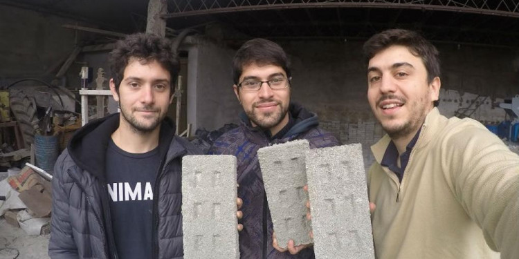 Tres jóvenes fabrican ladrillos con botellas plásticas para usar en la construcción